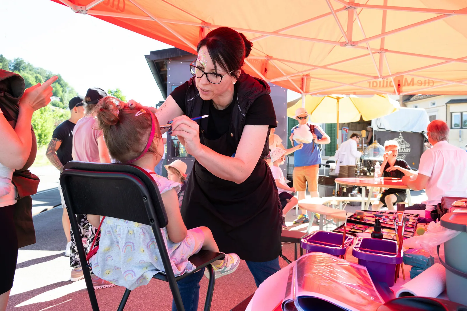 Jasmin Derrer schminkt an einem Sommerfest ein Kind