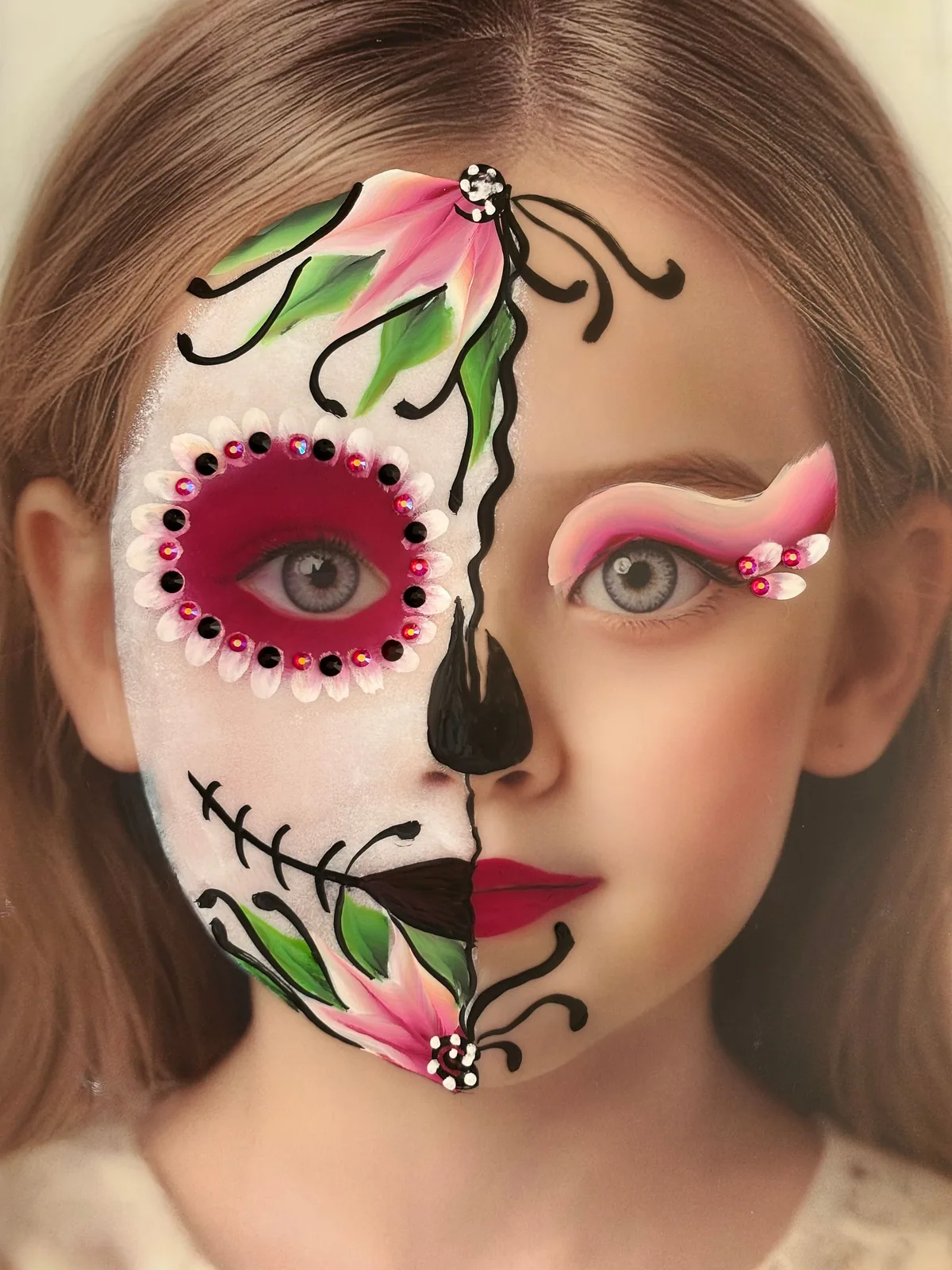 Halbseitig geschminktes Mädchen als Sugar Skull mit Blüten und Strasssteinen